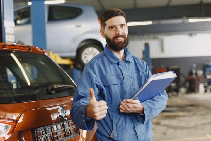 A mechanic completing a vehicle maintenance checklist
